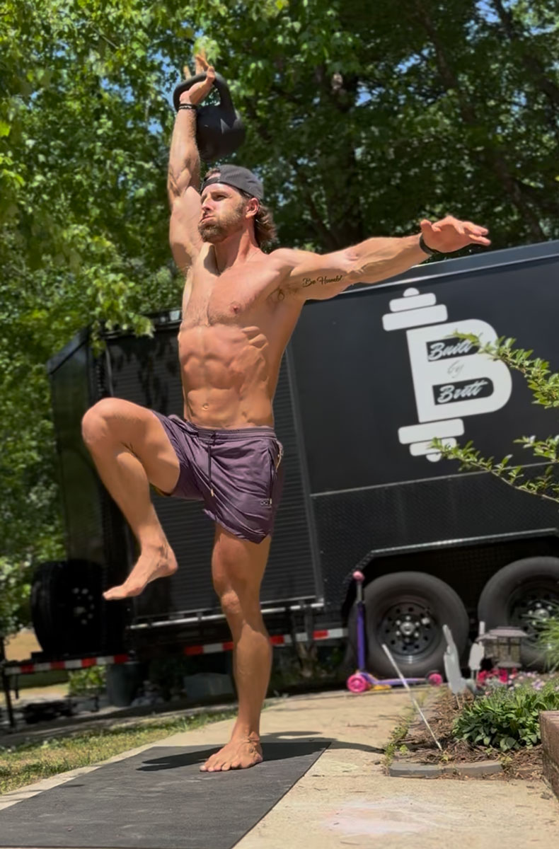 The coach is working out withe kettlebells.